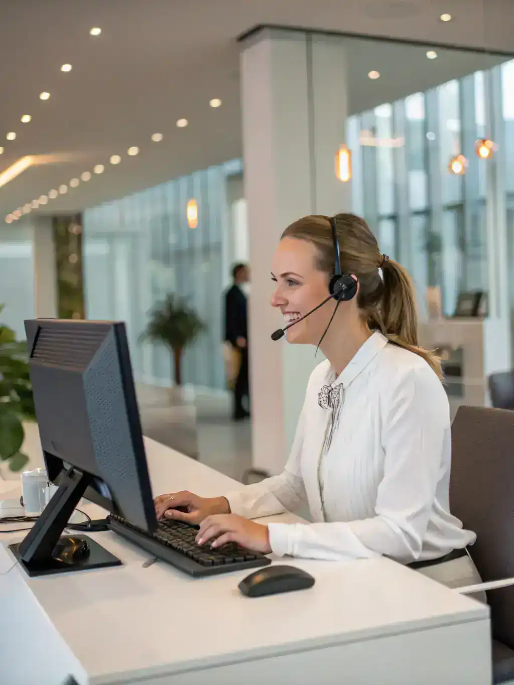 A friendly receptionist answering a call with a headset in a modern virtual office setting. The image should convey professionalism and efficiency.